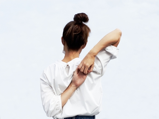 背中で手を組む